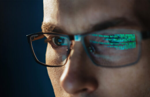 Many reading computer screen reflected in glasses