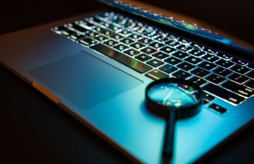 laptop with magnifying glass on keyboard